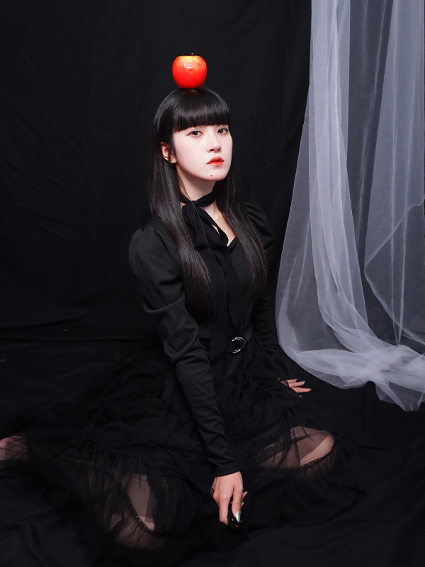 黒い布に座っている女の子