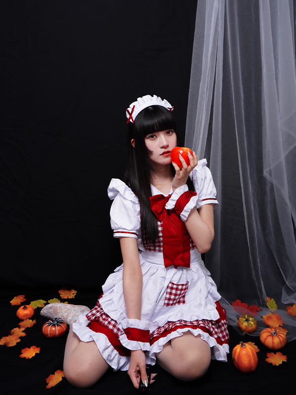 落ち葉に包まれてりんごを片手に持っているメイド服の女の子