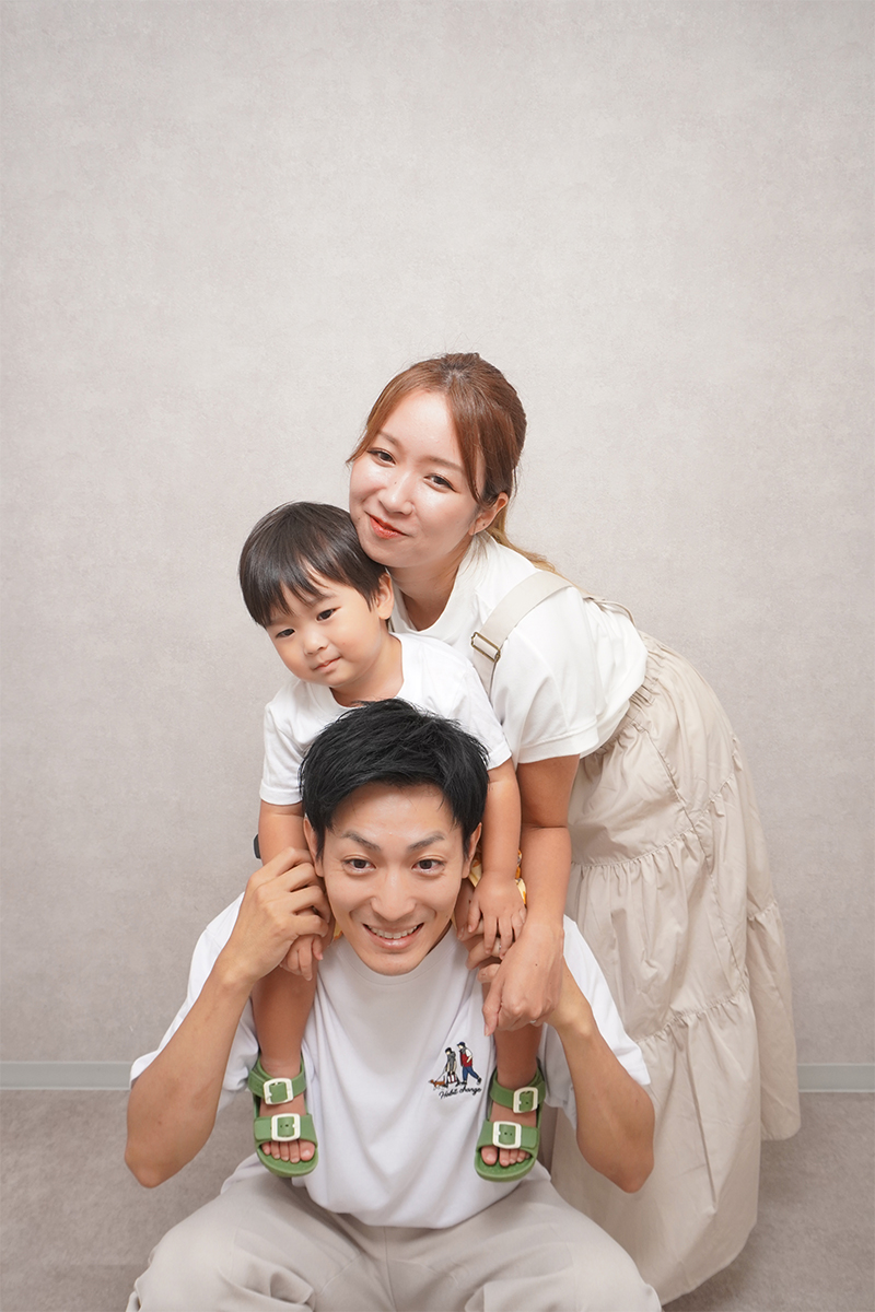 モルタル調の背景で撮影する家族